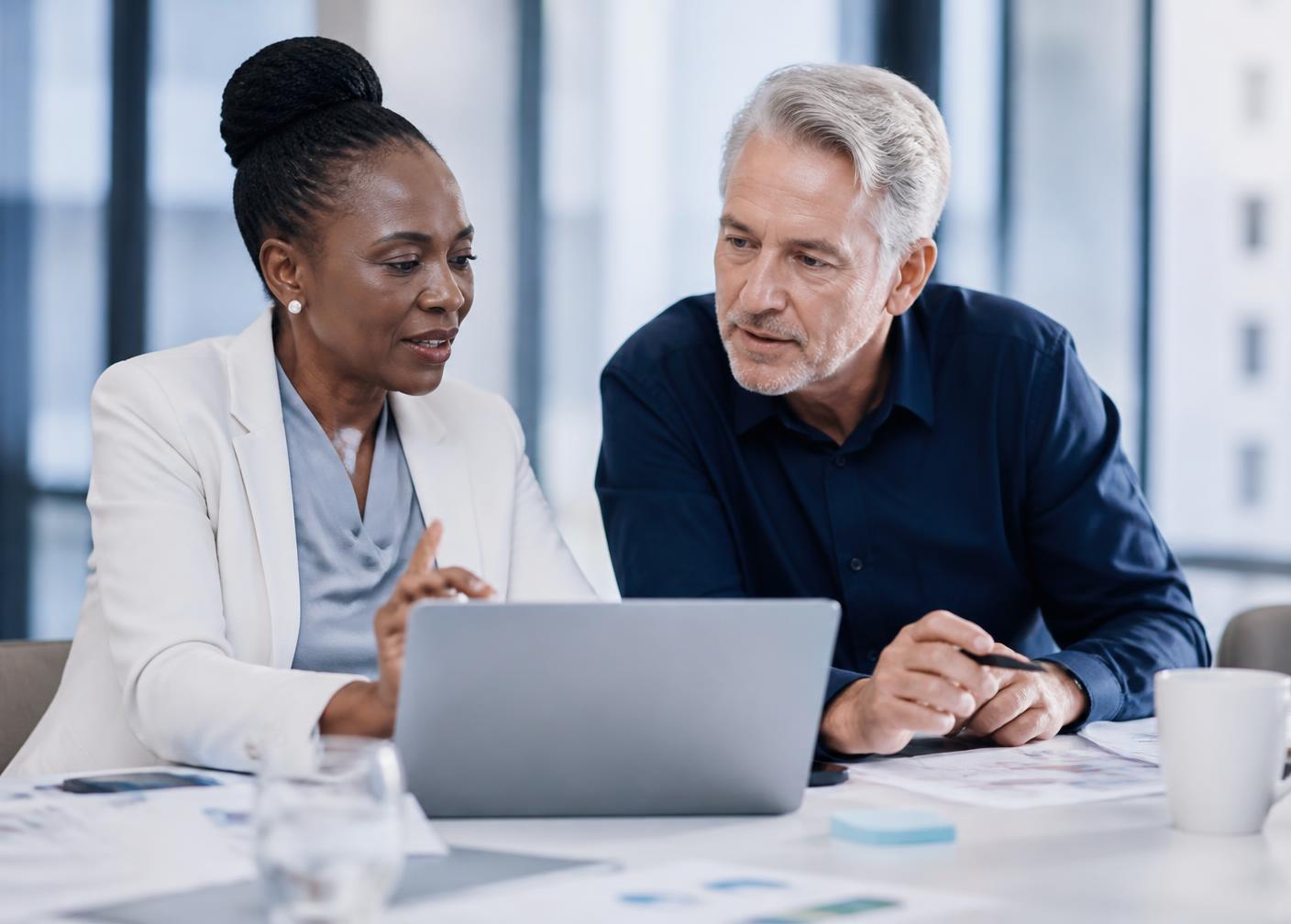 Two Catalyst CX consultants reviewing a migration plan with a client at a laptop